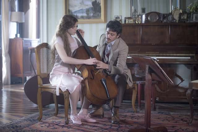 Felipe (Jesuíta Barbosa) ensina Cecília (Alice Wegmann) a tocar violoncelo (Foto: Globo/João Cotta)